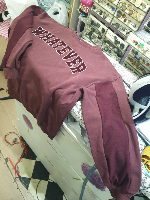 Un sweat shirt réparé avec une pièce de tissus sur la manche.